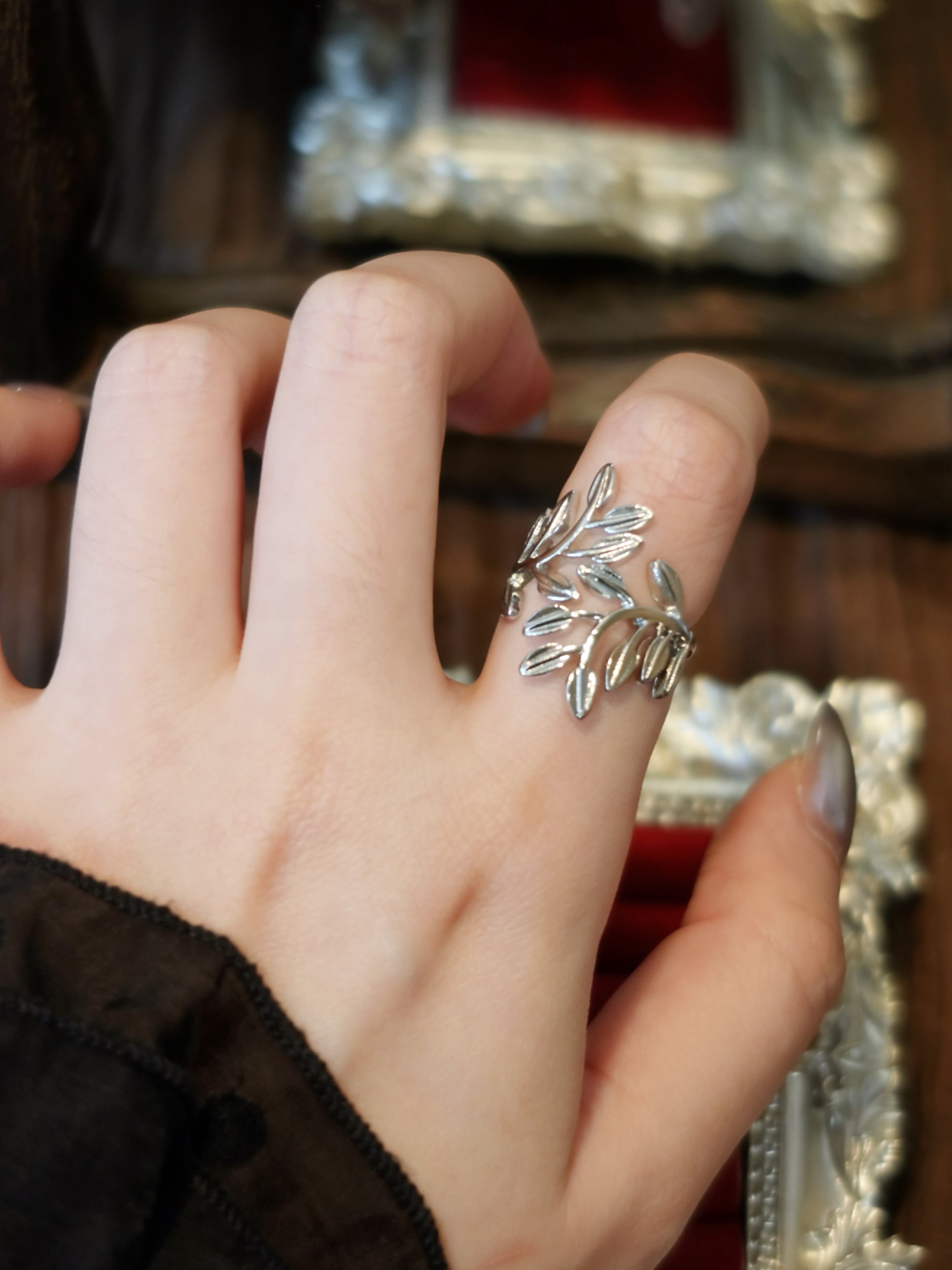 Antique silver laurel leaf ring wrapped around finger